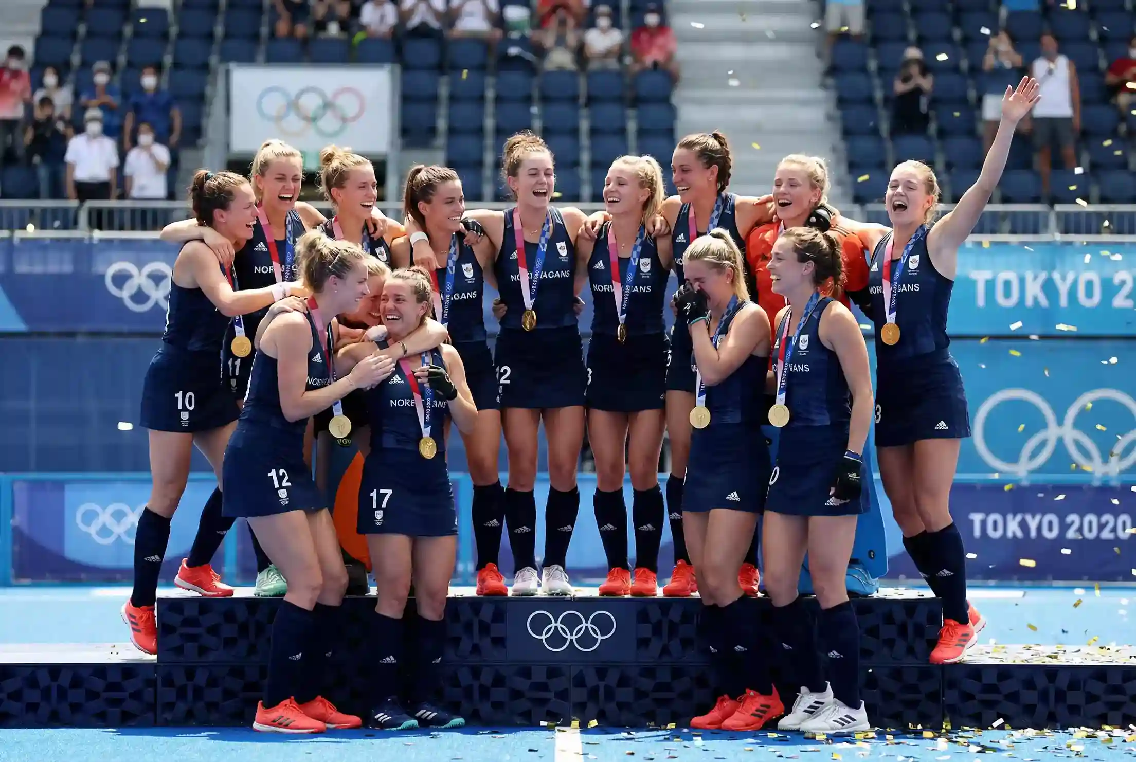Hockeyteam dat viert op het olympische podium met medailles