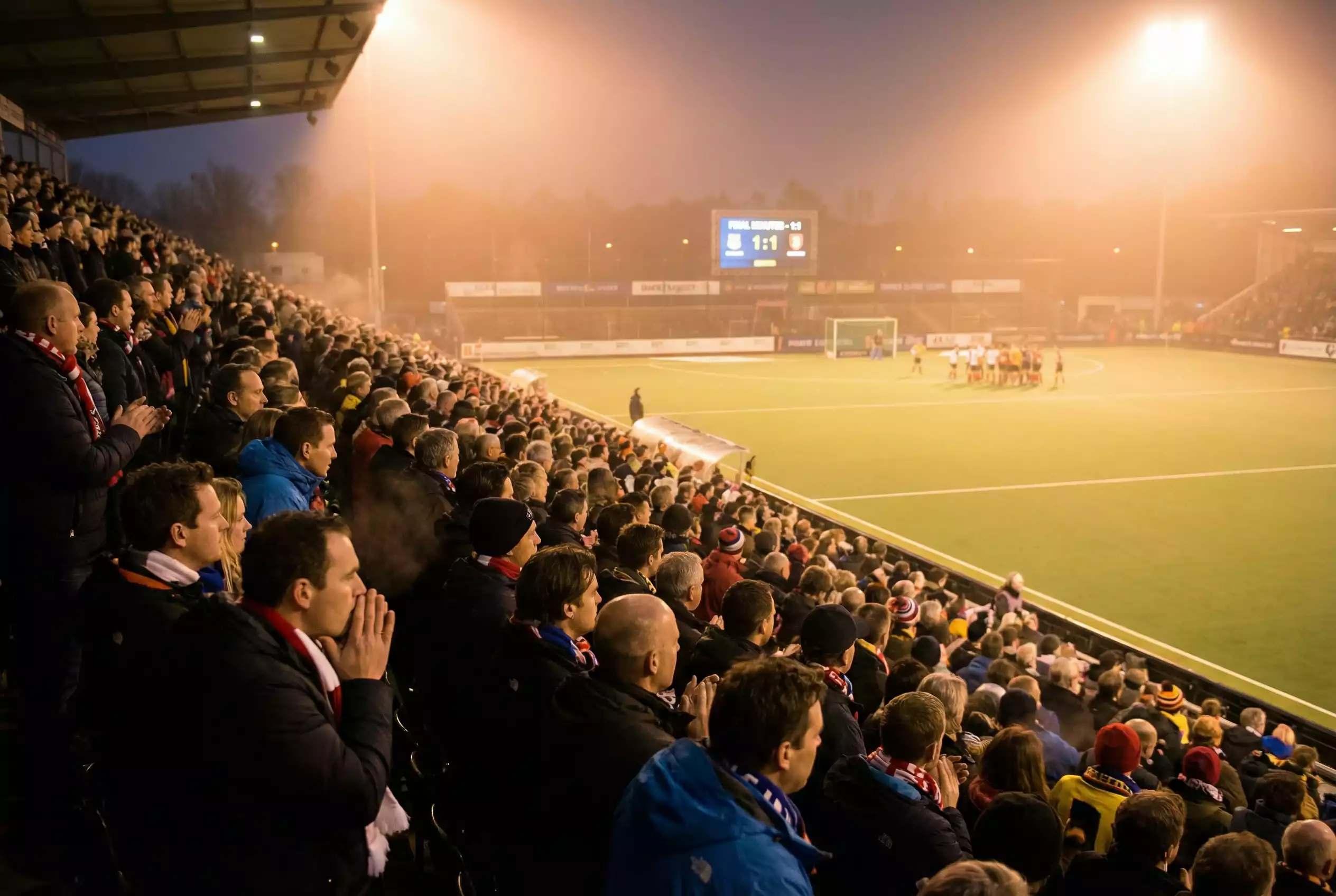 Hockeystadion met gespannen toeschouwers tijdens een beslissend moment