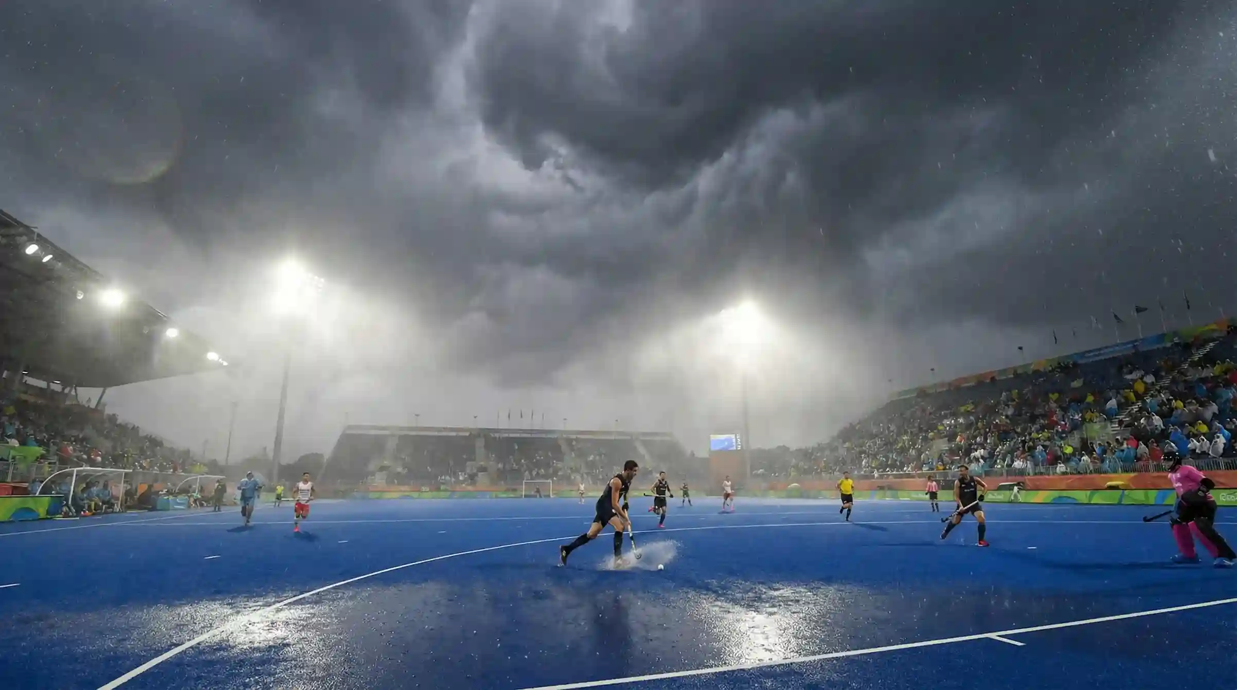 Hockeyveld onder wisselende weersomstandigheden met zichtbare regen of wind